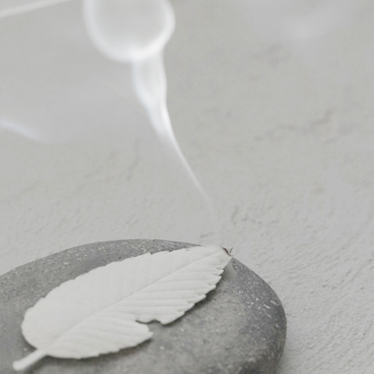 White incense burning atop a stone